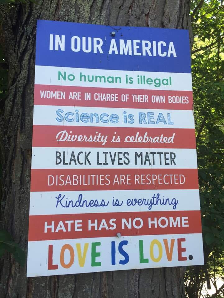 Sign with progressive social messages on tree.