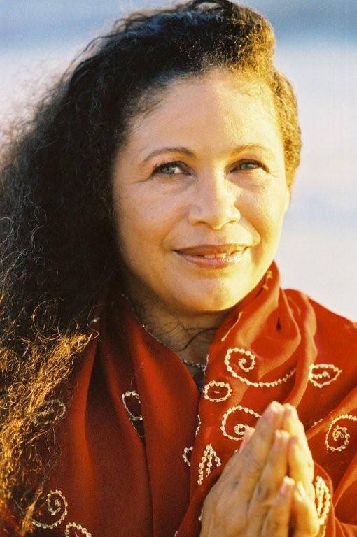 Woman in red shawl with clasped hands.