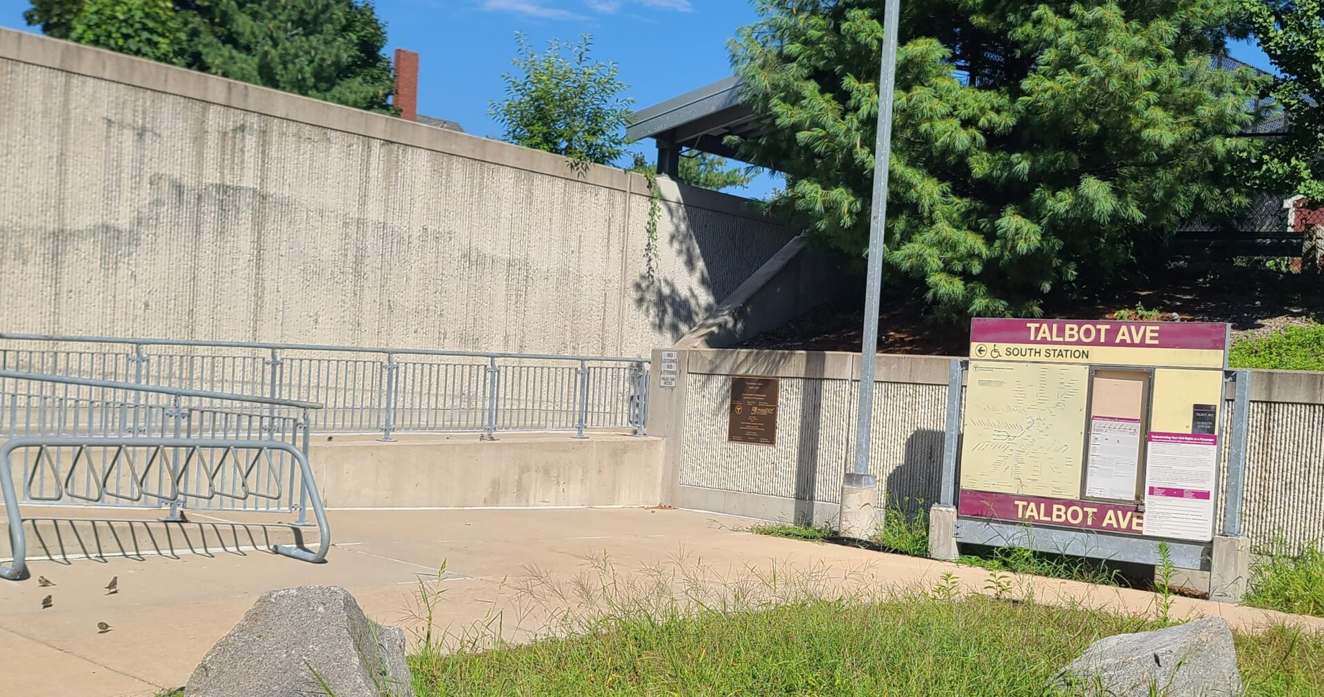 A concrete wall with trees in the background.